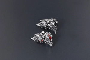 Detailed close-up of retro lion stud earrings with red and black crystals for men