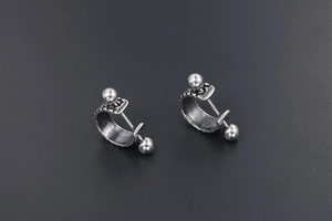 Detail of silver titanium steel hoop earrings with hammered texture and screw ball back