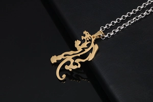 Detail of a two-tone dragon pendant on a rolo chain with a gold-plated finish