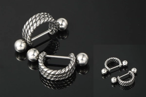 Macro detail of industrial style punk stud earrings with twisted cable metal texture