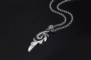 Macro d'un pendentif flamme argenté avec étoile gravée et chaîne rolo classique