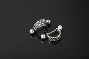 Detailed view of silver stainless steel twisted barbell studs with dual screw balls