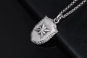 Détail macro du pendentif bouclier militaire argenté avec étoile boussole martelée