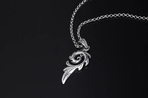 Gros plan d'un pendentif plume rétro en acier titane avec gravure d'étoile sur noir