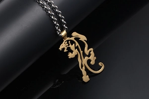 Macro view of golden hollow tiger pendant on silver chain over reflective black surface