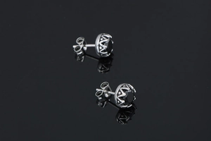 Détail macro de boucles d'oreilles vintage en titane avec pierre noire et bords ondulés