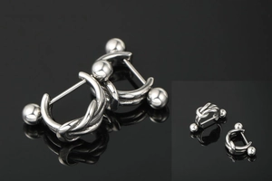 Macro detail of twisted knot silver steel earrings with ball screw back on black background