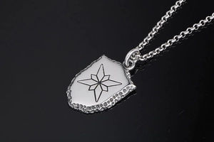 Détail macro d'un pendentif bouclier vintage avec étoile et texture martelée fine