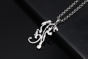 Detail view of silver hollow dragon pendant with punk style chain on dark leather surface