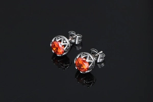 Détail de boucles d'oreilles couronne en argent avec pierres gemmes orange éclatantes
