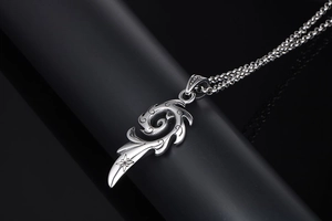 Détail du pendentif flamme argenté avec gravure d'étoile sur fond noir réfléchissant