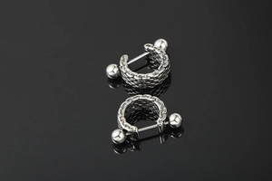 Detail of silver titanium steel earrings with punk style Cuban chain texture and reflective finish