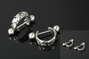 Detailed macro view of silver braided twist helix earrings with industrial metal texture