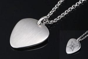 Makroaufnahme von Gitarrenplektrum-Anhänger mit gebürstetem Metall und Gravur
