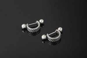 Detailed macro view of punk style stainless steel screw nut earrings with twisted rope design