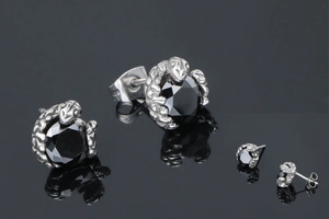 Détail macro de boucles d'oreilles griffes avec grandes pierres noires et poli argenté