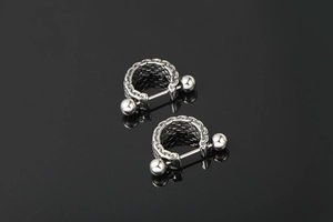Detailed view of silver titanium steel punk hoop earrings with woven chain texture