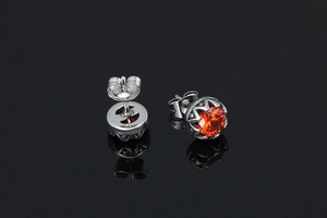 Détail macro des boucles d'oreilles couronne avec pierre de zircone orange facettée