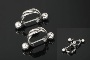 Dettaglio macro del piercing al capezzolo in acciaio al titanio argento con gabbia intrecciata