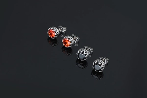 Vue macro de boucles d'oreilles en argent vintage avec zircons ronds orange et noirs
