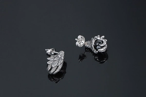 Macro view of vintage silver bird claw and feather earrings with black onyx beads