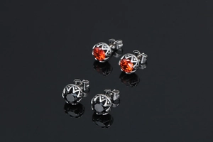 Détail de boucles d'oreilles rétro en acier titane avec gemmes rouges et noires serties en couronne