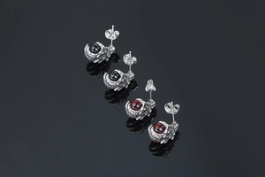 Detailed view of dragon claw earrings with polished black and red stones in 3D punk style