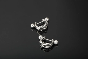 Macro detail of silver twist knot stud earrings with ball screw backs on black mirror