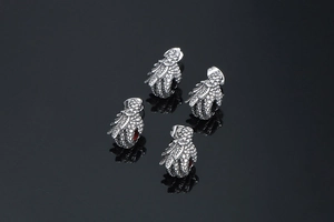 Detailed close-up of 3D punk dragon claw earrings featuring red rubies and silver scale finish