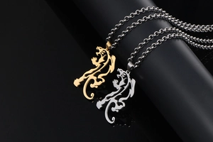 Detailed close-up of hollow leopard pendants in gold and silver finishes on black props