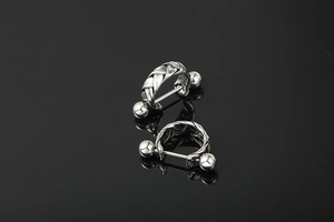 Close-up of silver braided twisted hoop earrings with industrial screw ball back on black
