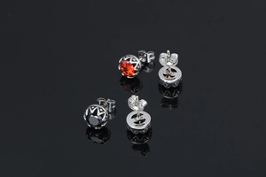 Détail de boucles d'oreilles rétro en acier titane avec gemmes orange et noires serties
