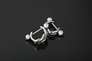 Detail of silver twisted titanium steel earrings with spherical screw back closure