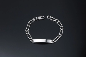 Détail d'un bracelet maille Figaro en argent avec plaque d'identité à graver