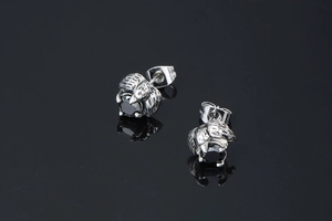 Macro view of gothic dragon claw stud earrings with black onyx stone in vintage silver