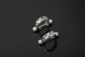 Macro shot of polished braided metal nipple shield with barbell and solid metal balls
