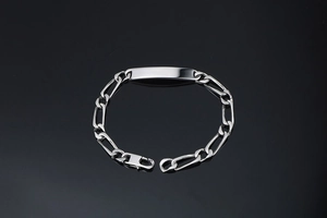 Détail du bracelet chaîne Figaro argenté avec plaque ID lisse et fermoir mousqueton