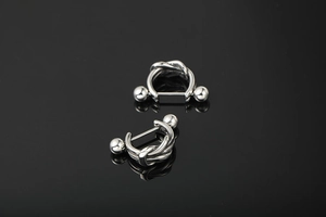 Close-up of woven knot silver titanium steel earrings with a punk ball closure