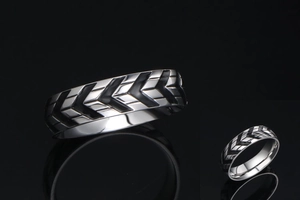 Detailed macro view of heavy-duty tire tread pattern on black titanium steel ring