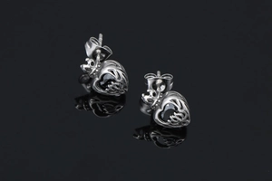Macro detail of crown heart earrings with black gems and polished silver finish