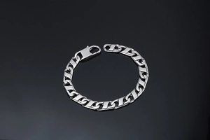 Détail d'un bracelet gourmette en acier titane argenté avec maillons plats et fermoir mousqueton