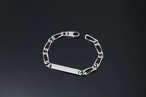 Détail du bracelet chaîne Figaro en argent avec une plaque d'identité rectangulaire polie