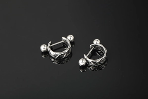 Detailed view of silver twisted braid hoop earrings with polished metal ball ends