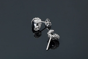 Détail macro de boucles d'oreilles serpent gothiques avec écailles et pierre de zircon noir