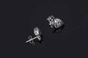 Detail view of heart-shaped dark gothic stud earrings with black gemstone and silver metal