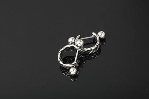Macro view of silver twisted braid texture on stainless steel hoop earrings with ball ends