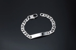Gros plan d'un bracelet gourmette en acier argenté avec plaque d'identification