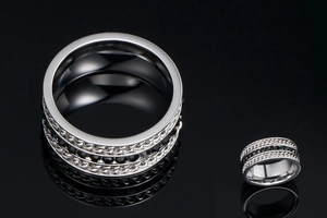 Detail of silver titanium steel wide ring with chain design and black rhinestones