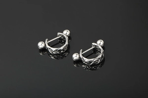 Macro detail of silver braided twist earrings showing metallic texture and smooth sphere ends
