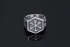 Macro view of vintage silver signet ring with engraved crossed arrows on hexagonal face